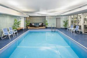 a swimming pool with chairs and a couch at Four Points by Sheraton Halifax in Halifax
