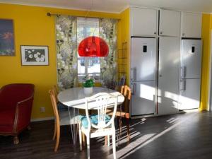 a dining room with a table and a refrigerator at Workers Stay - Furnished Housing Umeå Sverige in Klabböle
