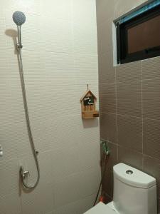 a bathroom with a toilet and a bird house on the wall at Yana's Place in Donsol