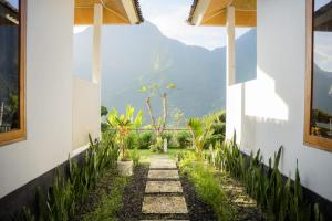 a pathway in a house with mountains in the background at Melaka Hill in Culik