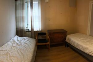a bedroom with a bed and a chair and a dresser at Workers Stay - Furnished Housing Umeå Sverige in Klabböle