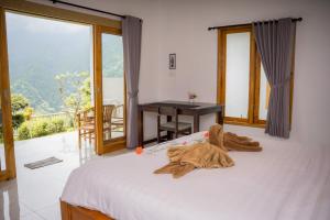 a bedroom with a bed with a desk and a window at Melaka Hill in Culik