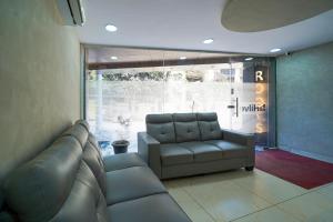 a living room with a couch and a chair at Open Hotel by Olive - Hilvon Business Hotel in Bangalore
