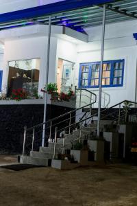 a white house with stairs in front of it at NAT CITY Hotel in Nuwara Eliya +1 photo