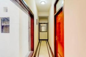 an empty corridor with a red door in a building at Hotel O Le Regent in Gurgaon