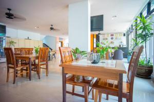 a dining room with a table and chairs at Neo Hotel Pattaya in Jomtien Beach