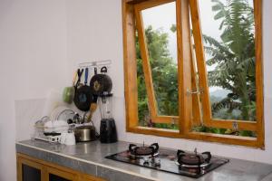 a kitchen counter with a stove and a window at Melaka Hill in Culik