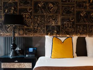 a bedroom with a bed and a desk with a yellow pillow at Hotel Sebastians in Amsterdam +60 photos