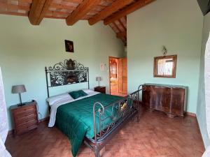 a bedroom with a bed with a green comforter at Colle dei Falchi in Fermo