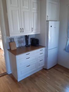 a kitchen with white cabinets and a white refrigerator at Workers Stay - Furnished Housing Umeå Sweden in Klabböle +2 photos