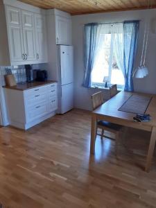 a kitchen with a table and a kitchen with a window at Workers Stay - Furnished Housing Umeå Sweden in Klabböle