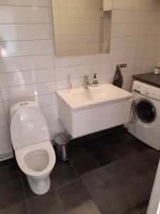 a bathroom with a white toilet and a sink at Workers Stay - Furnished Housing Umeå Sweden in Klabböle