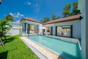 a swimming pool in the backyard of a house at lucky pool villas in Phuket