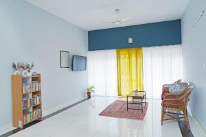a living room with a chair and a window at Orange valley Town Residency in Trivandrum