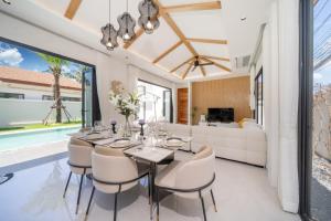 a dining room with a table and chairs and a couch at lucky pool villas in Phuket