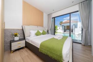 a bedroom with a bed and a large window at lucky pool villas in Phuket +58 photos