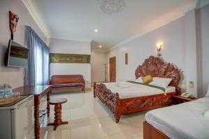 1 dormitorio con 2 camas, escritorio y TV en DV Angkor Villa, en Siem Reap