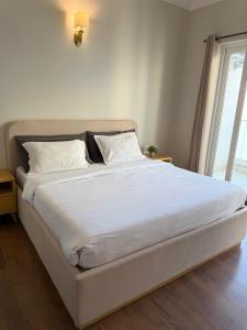 a large white bed in a room with a window at Central Park, The Rooms 1 & 2 BHK Poolview Suites in Gurgaon +8 photos