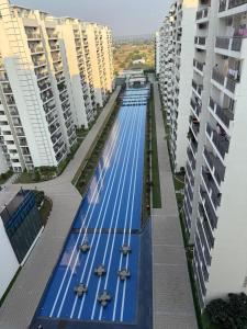 a swimming pool in the middle of some buildings at Central Park, The Rooms 1 & 2 BHK Poolview Suites in Gurgaon