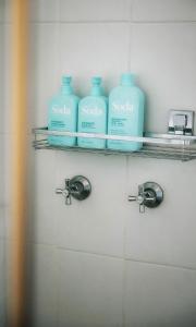 a bathroom with three bottles of soap on a shelf at Maison Macquarie in Dubbo +32 photos