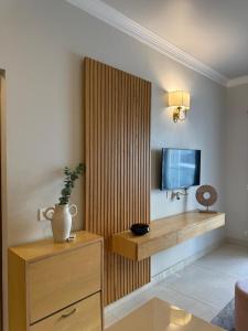 a living room with a tv and a wooden partition at Central Park, The Rooms 1 & 2 BHK Poolview Suites in Gurgaon