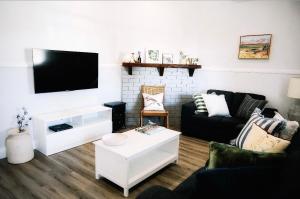 a living room with a couch and a tv at Maison Macquarie in Dubbo