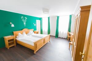 a bedroom with a bed and a green wall at Stadthotel Augsburger Hof in Landsberg am Lech +22 photos