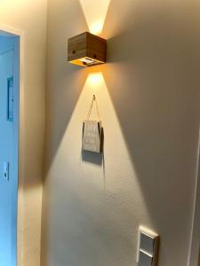 a light on a wall with a clock on it at lüttjeseeblick13 in Nordstrand