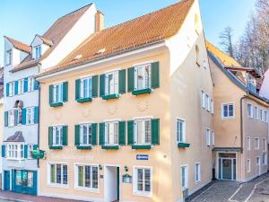 a building with green shutters on a street at Stadthotel Augsburger Hof in Landsberg am Lech