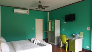 a bedroom with green walls and a bed and a desk at Khao Sok Country Resort in Khao Sok National Park