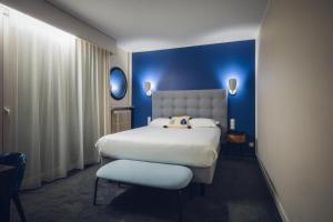 a bedroom with a large bed and a blue wall at Cit'Hotel Logis De Brou, Bourg en Bresse RENOVE EN 2026 in Bourg-en-Bresse +58 photos