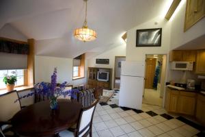 a kitchen with a table and a white refrigerator at Abbey Archway Inn in Fairbanks