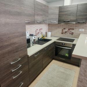 a kitchen with wooden cabinets and a sink at Magic Apartments 3 in Miercurea-Ciuc +5 photos