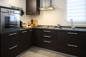 a kitchen with dark brown cabinets and a sink at Ca' Dei Coppi in Solignano Nuovo