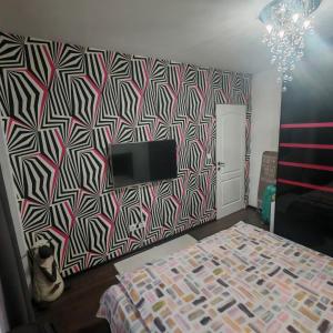 a bedroom with a bed and a tv on a wall at Magic Apartments 3 in Miercurea-Ciuc