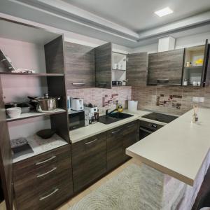 a kitchen with wooden cabinets and a white counter top at Magic Apartments 3 in Miercurea-Ciuc
