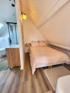 a small bedroom with a bed and a bathroom at L'escapade ansérienne in Oye-Plage