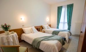 a hotel room with two beds and a table at Dal Brascin in Corio