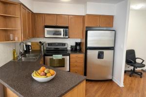 a kitchen with a bowl of fruit on a counter at Skyline Retreat Floor-to-Ceiling Views in Mississauga