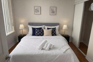 a bedroom with a white bed with two towels on it at Skyline Retreat Floor-to-Ceiling Views in Mississauga