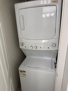 a washer and dryer sitting on top of a refrigerator at Skyline Retreat Floor-to-Ceiling Views in Mississauga