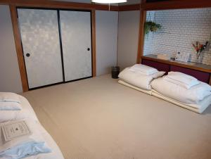 a room with two beds and a window at SAMURISE DARUMA in Fujiyoshida