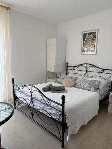 a bedroom with a bed with a black frame at Guesthouse Kamarin in Pomena
