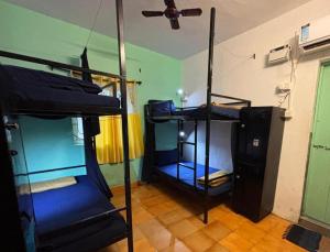 a room with three bunk beds and a ceiling at Mandala House - Party hostel in Palolem