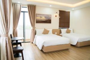 a hotel room with two beds and a window at Black Win Hotel Phu Yen in Mỹ Hòa (1) +25 photos