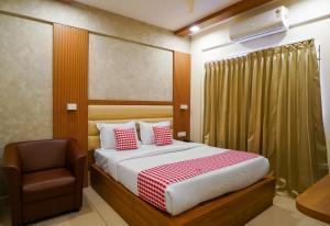 a bedroom with a bed and a chair at Open Hotel by Olive - Hilvon Business Hotel in Bangalore