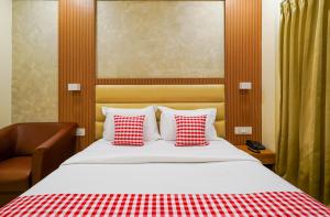 a bedroom with a bed with red and white pillows at Open Hotel by Olive - Hilvon Business Hotel in Bangalore