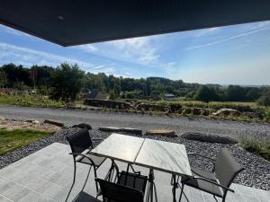 a table and chairs sitting on a patio at Pétalya Lodge in Montcornet