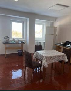 a kitchen with a table and chairs and a refrigerator at Оазис in Lutsk