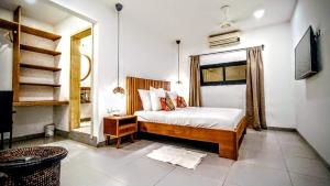 a bedroom with a bed and a television in it at L'Hédone, hôtel de charme in Ouagadougou